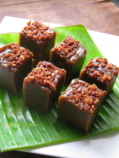 Several Pieces Of Food On A Green Plate With Banana Leaves And Sauce In