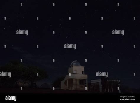 Observatorio Astronómico en noche estrellada con camping y árbol