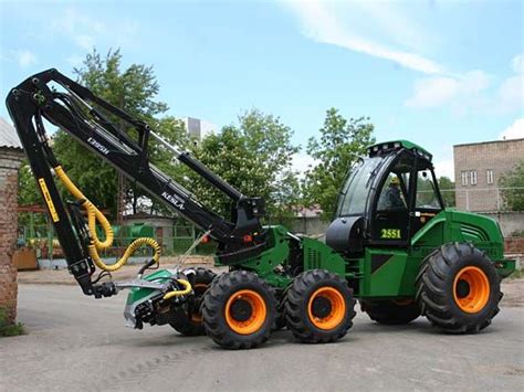 A Green Tractor With Orange Wheels Parked In Front Of A Brick Building