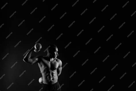 Premium Photo Isolated African Muscular Man With Dumbbells On Dark