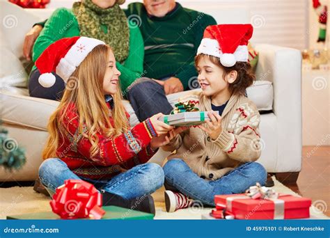 Siblings Giving Gifts To Each Other at Christmas Stock Image - Image of ...