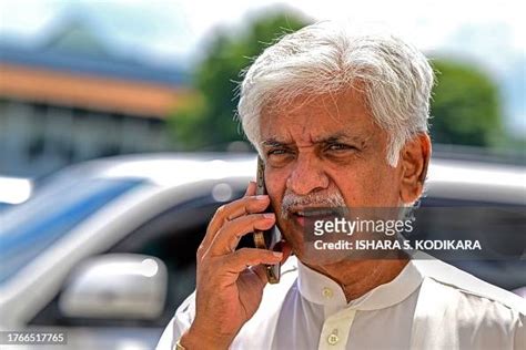 Sri Lanka's former cricket captain Arjuna Ranatunga uses his phone as ...