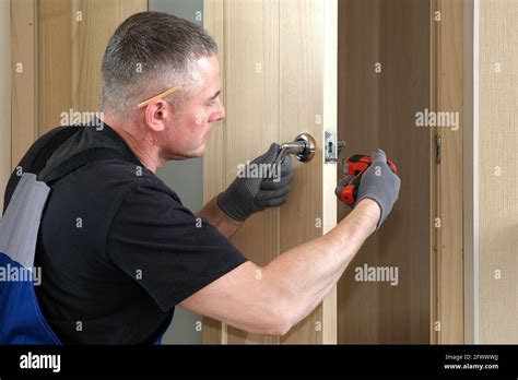 Handyman Carpenter Installs An Internal Door Lock Wooden Interior Door