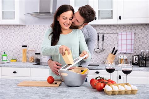 Homem Que Beija A Mulher Ao Fazer Alimentos Frescos Deliciosos Foto De