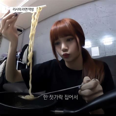 A Woman Eating Noodles With Chopsticks In Her Hand