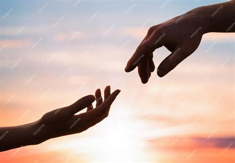 Premium Photo Silhouettes Of A Female And Male Hand Reaching Out To