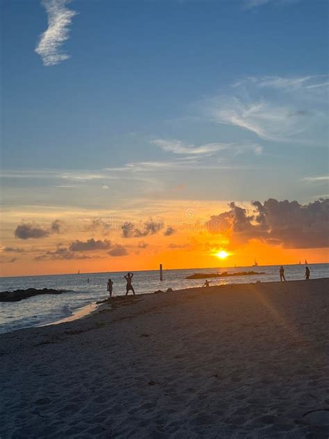 Vertical Shot Of A Bright Orange Sunset Sky Over A Seashore With