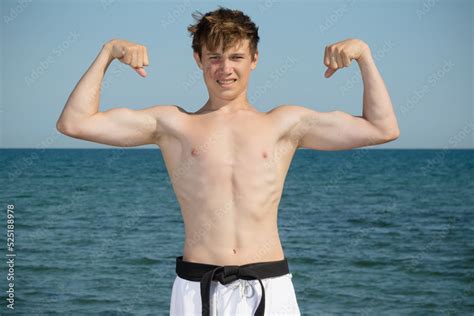 A Shirtless 17 Year Old Teenage Boy Flexing His Muscles ภาพถายสตอก