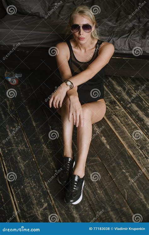 Woman Posing In Sunglasses Sitting Next To The Bed With His Hands