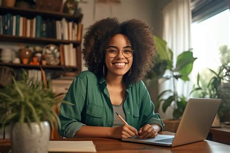 Premium Photo A Woman Sits At A Desk With A Laptop And Smiles At The