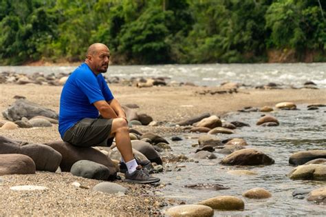 Un Solo Hombre Sentado A La Orilla Del Río En La Selva Amazónica