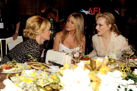 Three Women Sitting At A Table Talking To Each Other