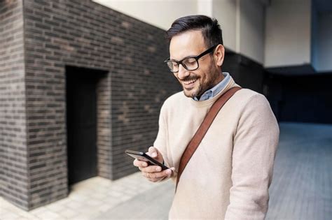 Premium Photo A Happy Smart Casual Man Scrolling On The Phone Outside