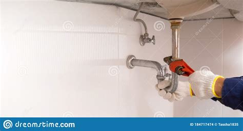 Plumber Fixing White Sink Pipe With Adjustable Wrench Stock Photo