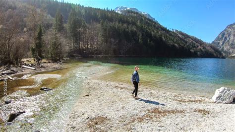 A Woman Walking Along The Shore Of Leopoldsteiner Lake In Austria The