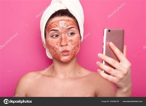 Beautiful Female Model Has Scrub Mask On Face Wrapped In Towel Poses Half Naked Taking Selfie