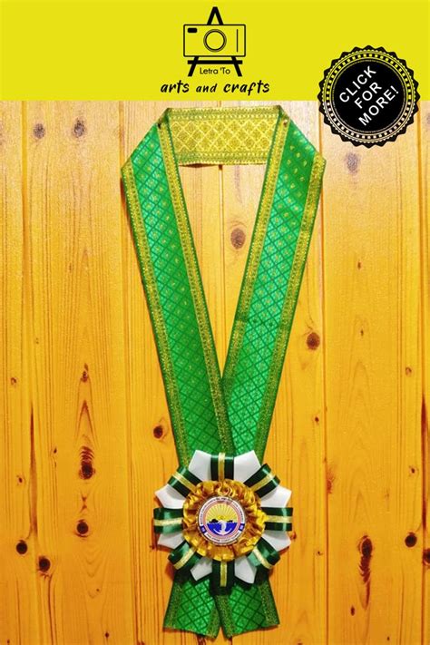 A Green Ribbon With A Gold Medal On It