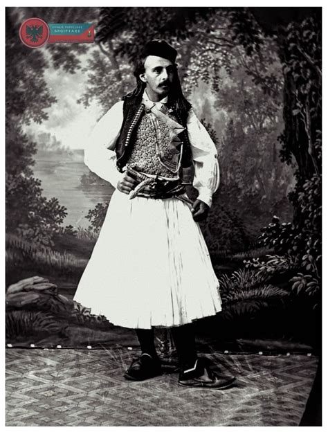 An Old Photo Of A Man In Traditional Clothing Standing With His Hands