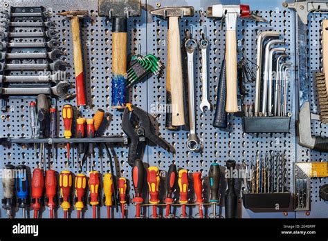 A Collection Of Assorted Tools Hanging On The Wall With A Work Bench