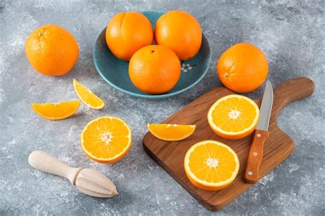 Fatias De Frutas Laranja Laranjas Inteiras Em Uma Placa De Madeira