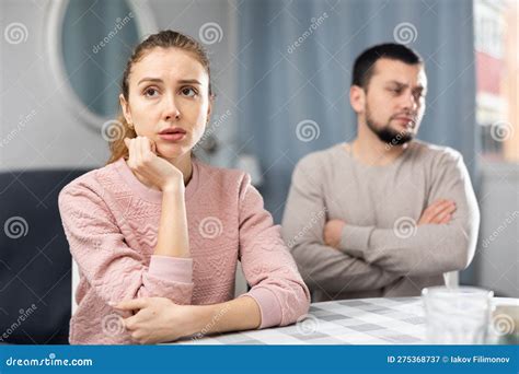 Wife And Husband Sitting At Table At Home And Quarreling Stock Image