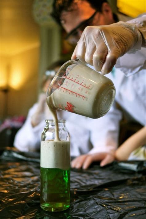 A Person Pouring Something Into A Glass Bottle