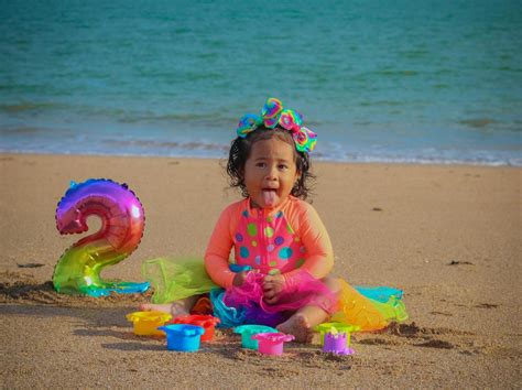 A Little Girl Playing with Sand on the Beach · Free Stock Photo