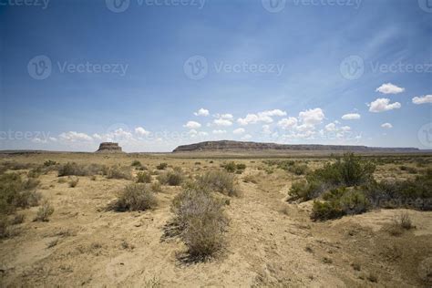 an arid landscape with sparse grass and bushes in the foreground, under ...