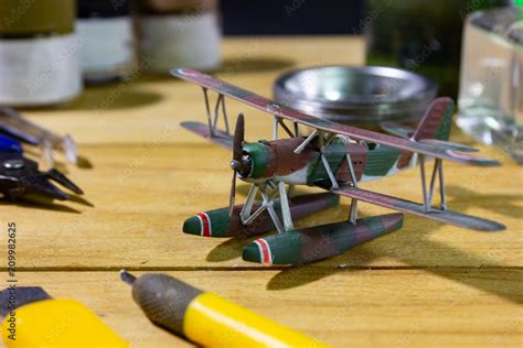 Plastic model WW2 biplane with scale model tools on wooden workbench ...