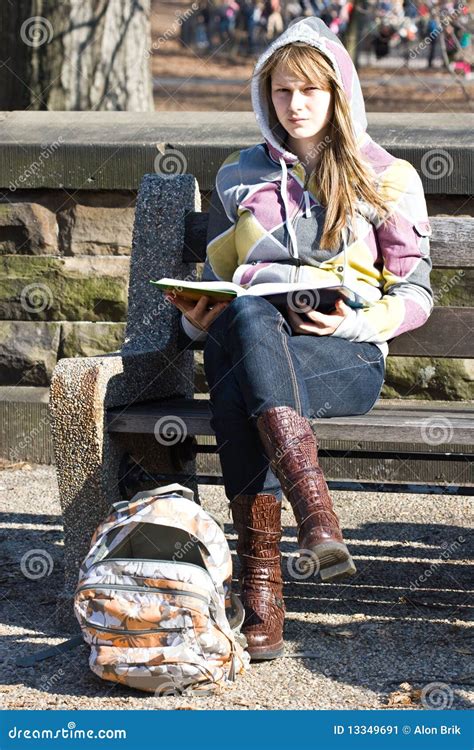 Menina Nova Do Adolescente Que Senta Se Em Um Banco Livro Imagem De