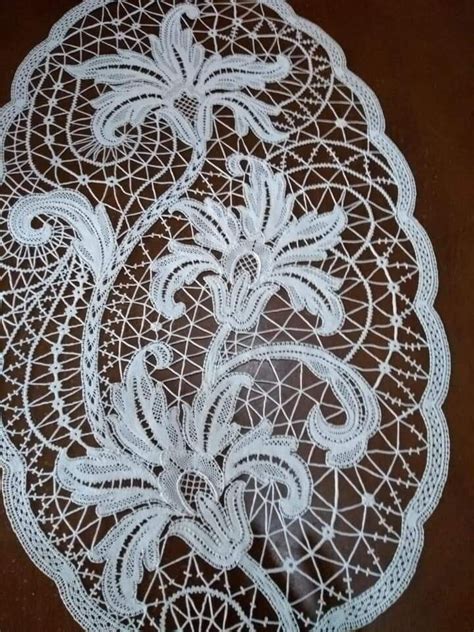 A White Doily With An Intricate Design On The Top And Bottom Sitting