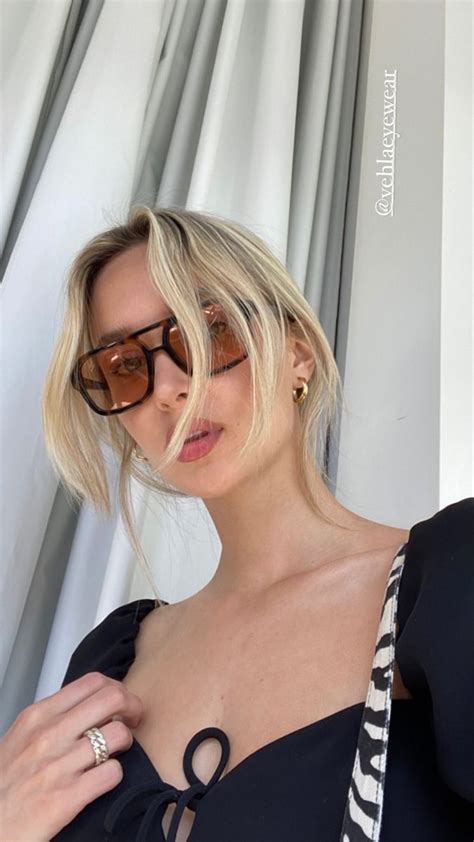 A Blonde Woman Wearing Sunglasses And A Black Top