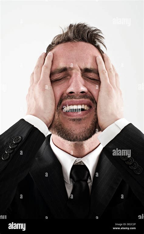 Desperate Young Man Wearing A Suit Holding His Hands To His Face