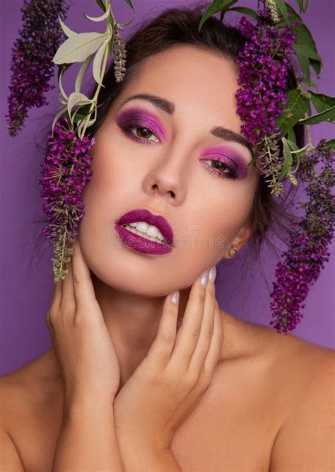 Beautiful Woman Wearing Purple Makeup With Flowers Around Her Face