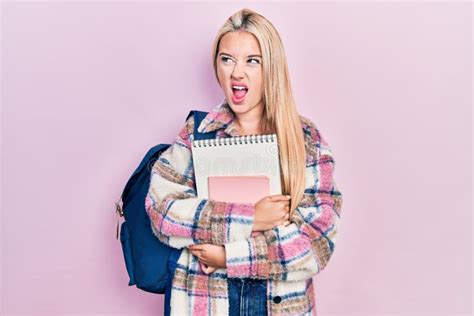 Jovencita Rubia Sosteniendo Una Mochila Estudiantil Y Libros Enojados Y