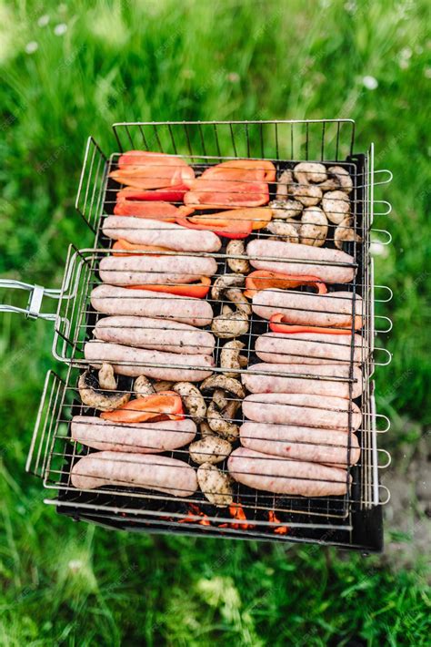 Premium Photo Grill Sausages With Vegetables And Spices On A Brazier Top View Assorted