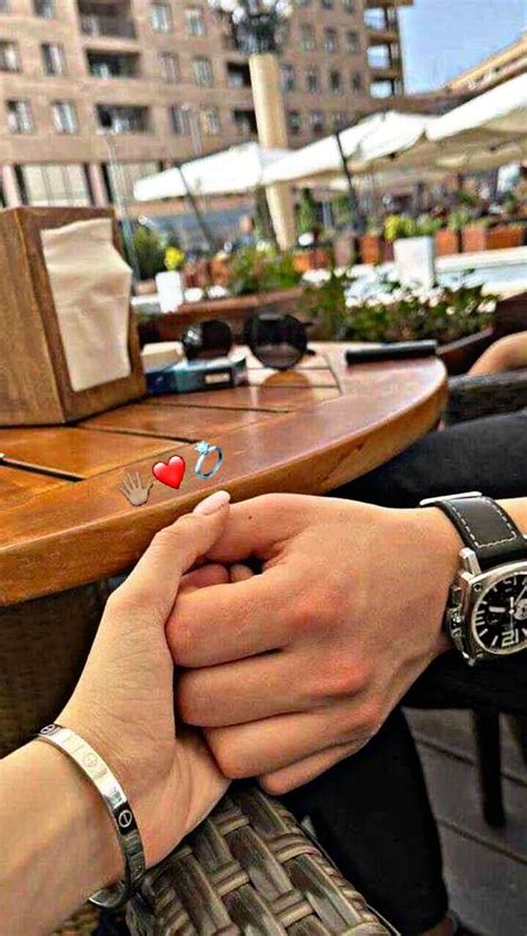 Two People Holding Hands While Sitting At A Table