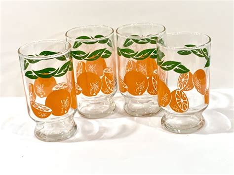 Four Glasses With Oranges And Leaves Painted On Them