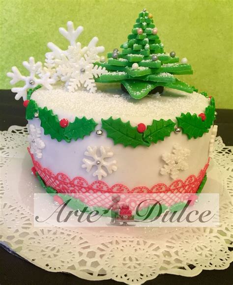 A Decorated Christmas Cake Sitting On Top Of A White Doily