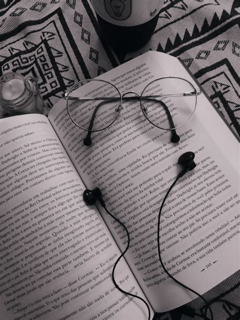 An Open Book With Headphones On Top Of It Next To A Cup Of Coffee