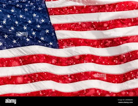 American Flag Flapping In The Wind During A Snow Squall In Mecosta