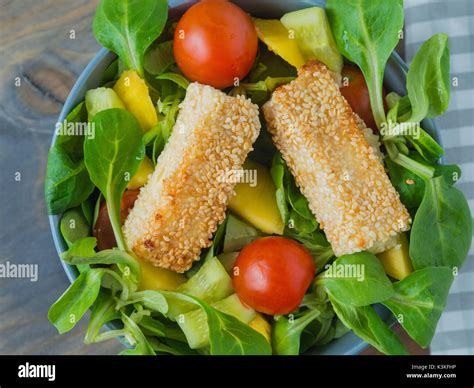 Gebackene Feta K Se In Sesam Kruste Auf Gemischter Salat Mit Mango