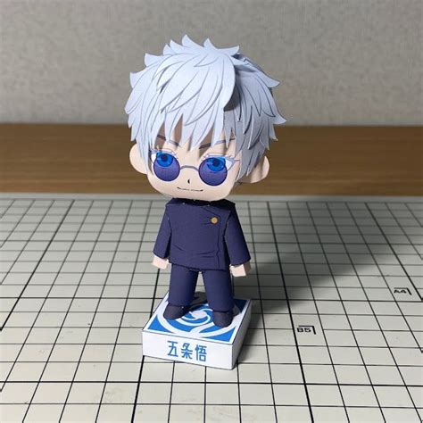 An Anime Figurine Is Sitting On A White Box With Blue Eyes And Grey Hair