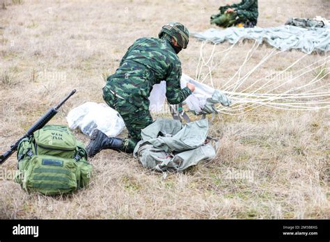 A Royal Thai Army Paratrooper Gathers His T Parachute After Landing