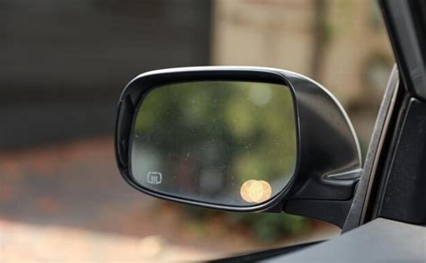 O espelho retrovisor do carro refletindo uma estrada panorâmica atrás o