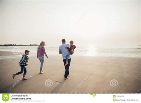 Familia Que Recorre En La Playa Foto De Archivo Imagen De Agua Ropa