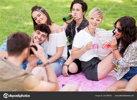 Friends photographing at picnic in summer park Stock Photo by ©Syda_Productions 203198332