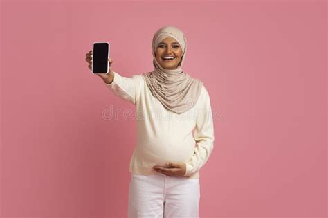 Pregnant Muslim Lady In Hijab Touching Belly And Demonstrating Blank