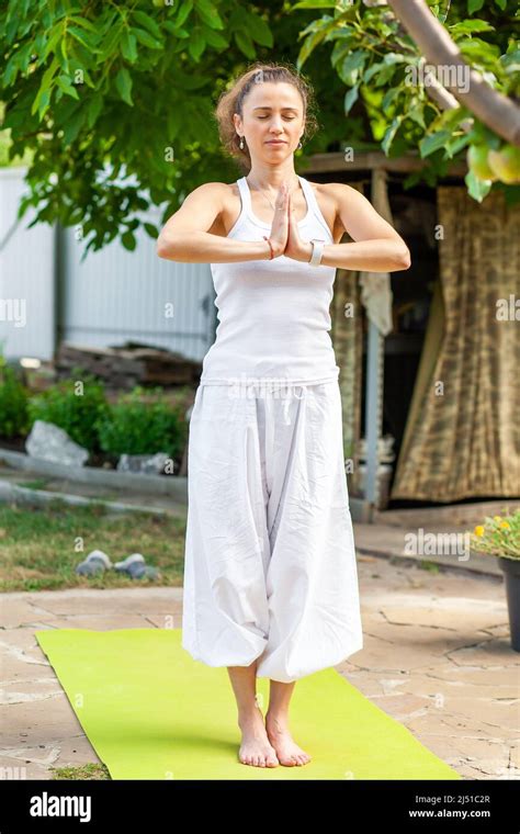 Young woman practices yoga in the summer garden - Namaskar Mudra. Surya ...