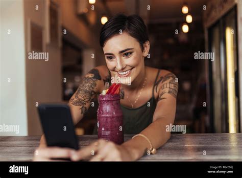 Smiling Woman Taking A Selfie With A Smoothie Placed In Front Of Her